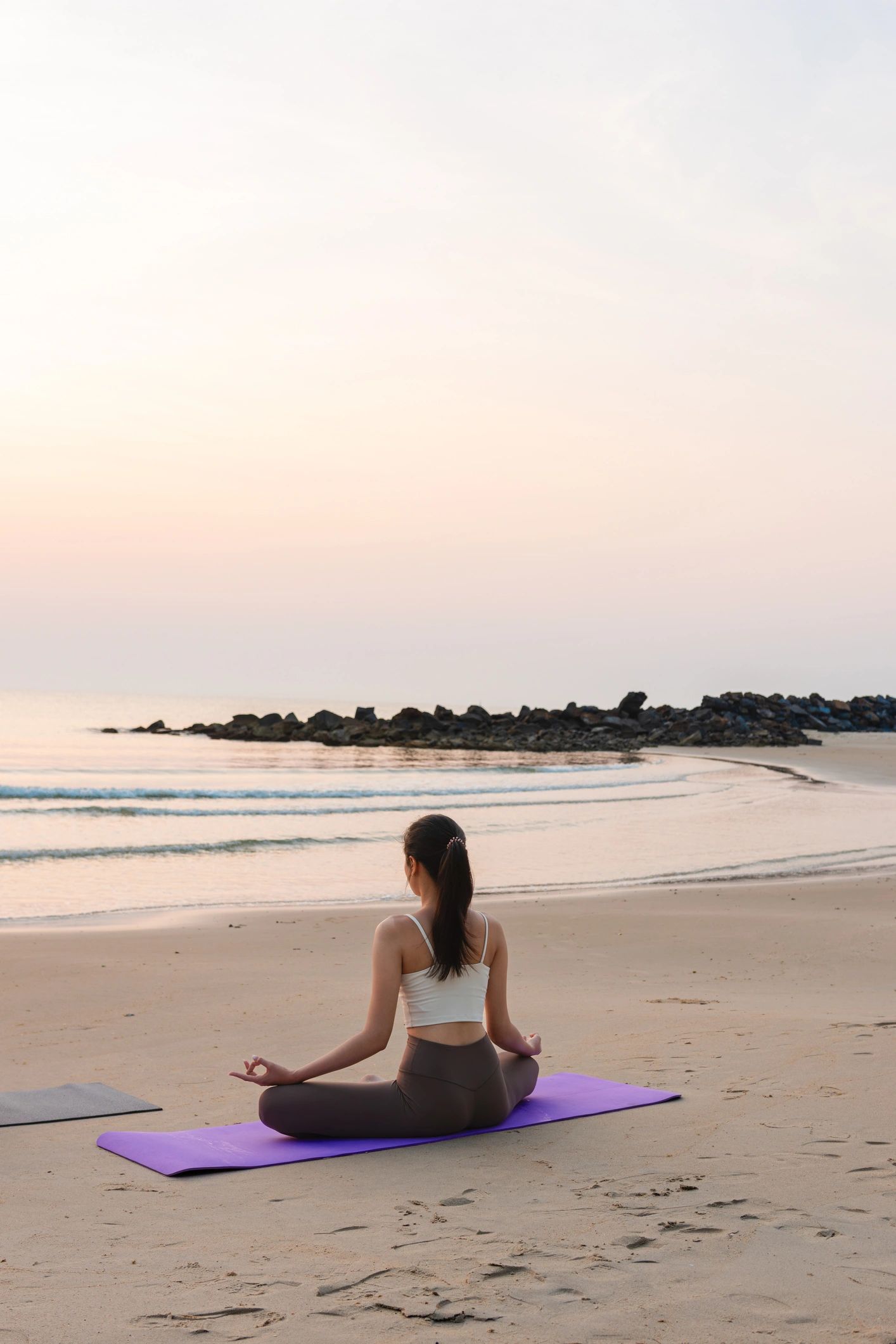 Person meditating outdoors at sunrise